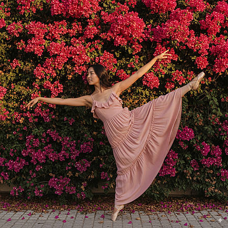 Elegant ballet pose in pink dress before bougainvillea – Dance and aesthetics